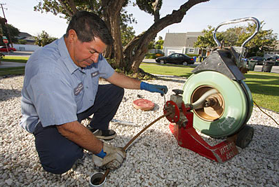 Miami Beach plumbing contractor snakes a drain line with a power auger
